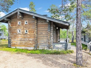 Une cabane en bois avec un porche et une petite terrasse.