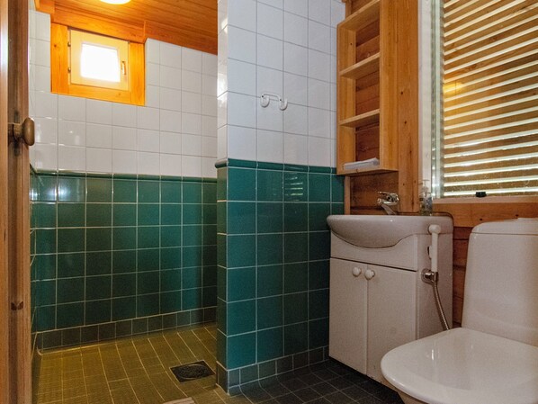 Un baño con inodoro, lavamanos y zona de ducha.