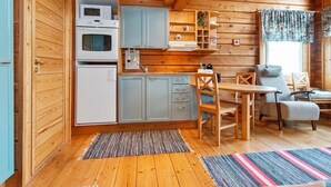 A cozy cabin interior with a kitchen, dining area, and a window with curtains. - Pikku-veke by Interhome (Inari)