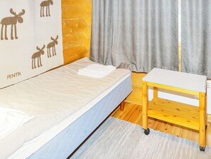 Un dormitorio con cama, una mesita de madera y una pared decorada con estampados de animales.
