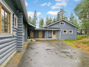 A log cabin with a front porch and a garage.
