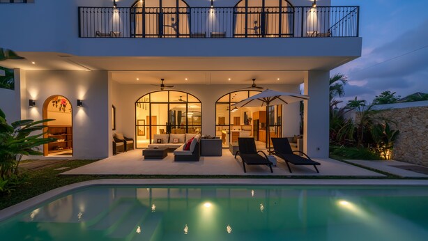 Ein modernes Haus mit Pool, Außenbereich und Balkon.