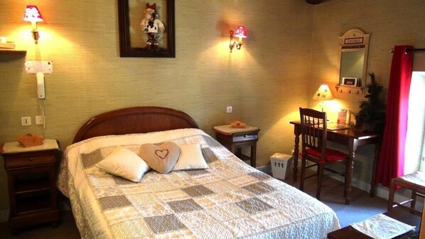 A neatly arranged bedroom with a bed, bedside tables, a desk, and a chair. - hotel le clos du montvinage (Etreaupont)