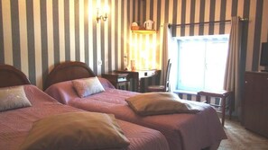 Une chambre avec deux lits, un bureau et une chaise.