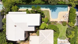 A residential area with a swimming pool, surrounded by greenery and houses.