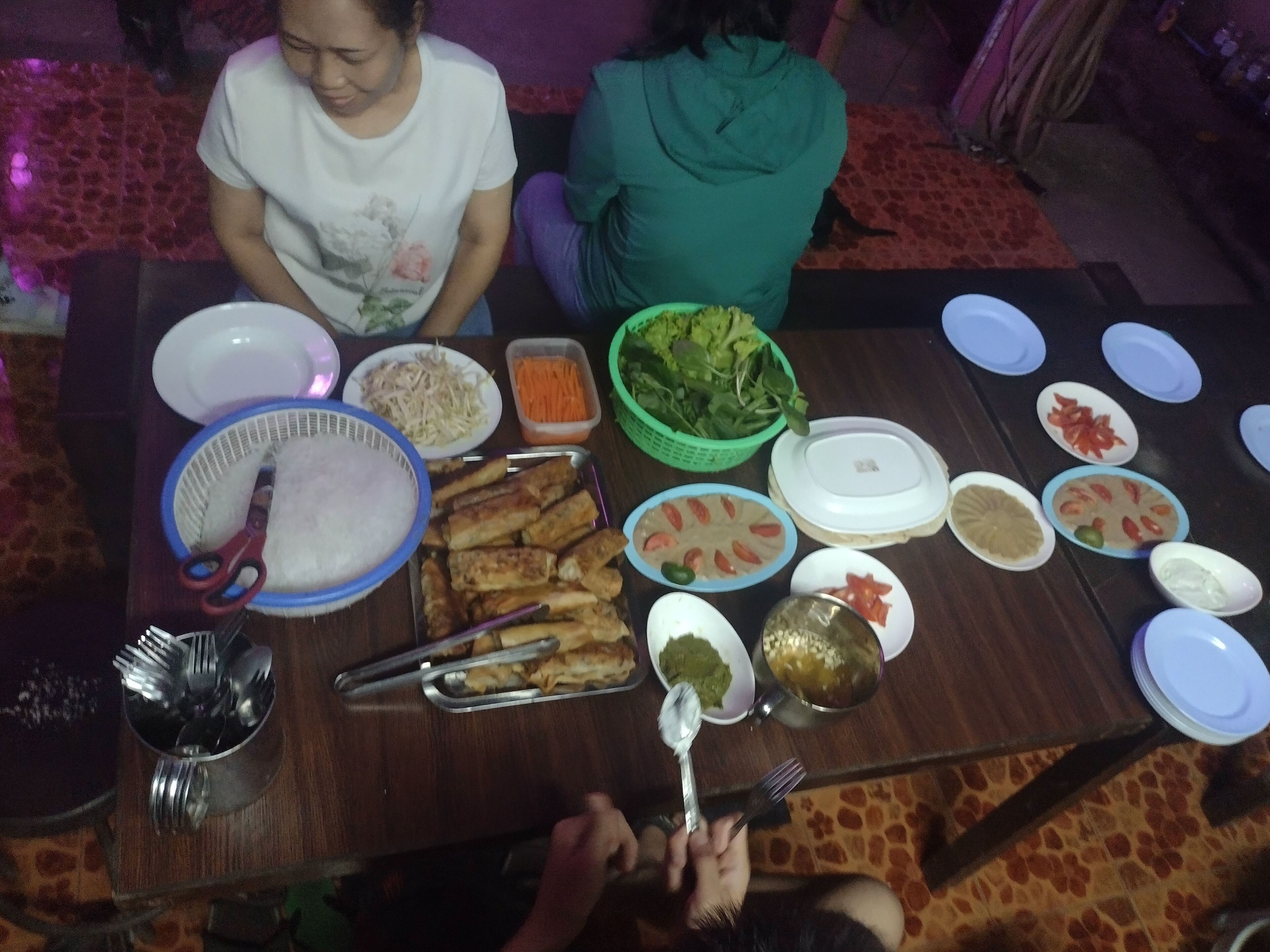 A dining table with various dishes and utensils.
