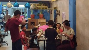 Un comedor con mesas y sillas, globos y plantas en macetas.