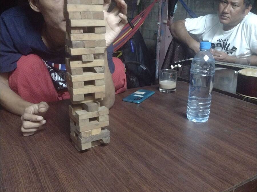A wooden block tower on a table, a water bottle, and a smartphone.