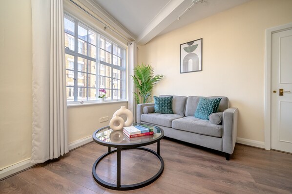 Relax in this inviting living room with a sofa, coffee table, and artwork.
