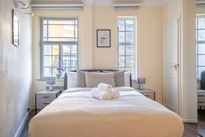 Relax in a spacious room with a large bed, two bedside tables, and a framed picture above.