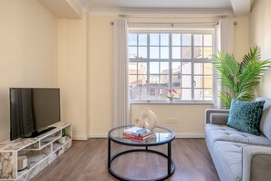 Relax in this stylish living room with a flat-screen TV, comfortable sofa, and city views.