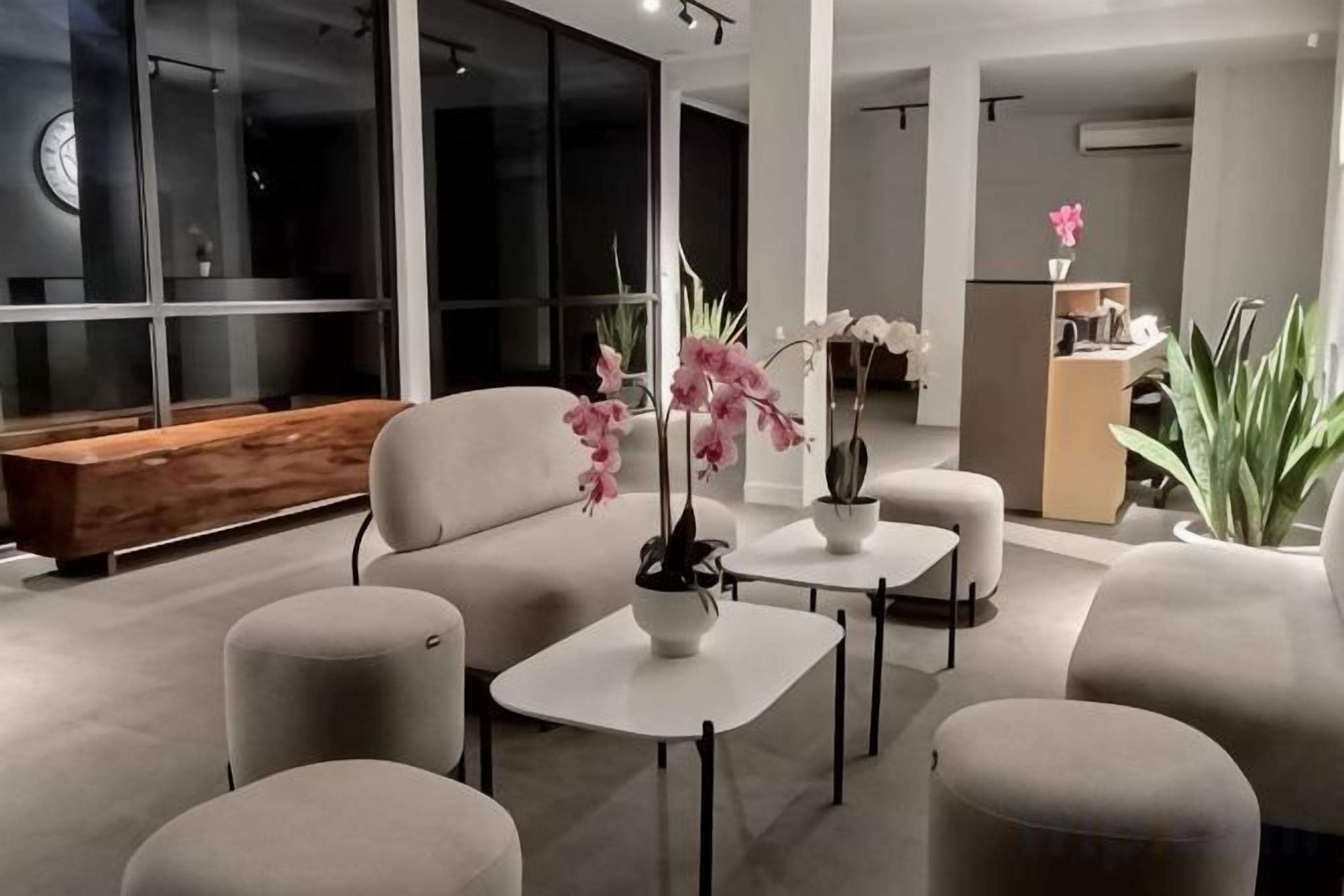 A modern living room with a sofa set, a coffee table, and potted plants.