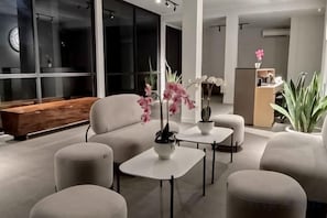 Una sala moderna con un conjunto de sofás, una mesa de centro y plantas en macetas.