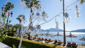 A beachside resort with lounge chairs, umbrellas, and decorative hanging ornaments. - Prime Beach Hotel - All inclusive (Marmaris)