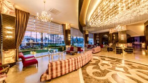 A luxurious hotel lobby with a large seating area, a grand chandelier, and a view of the outdoors. - Prime Beach Hotel - All inclusive (Marmaris)