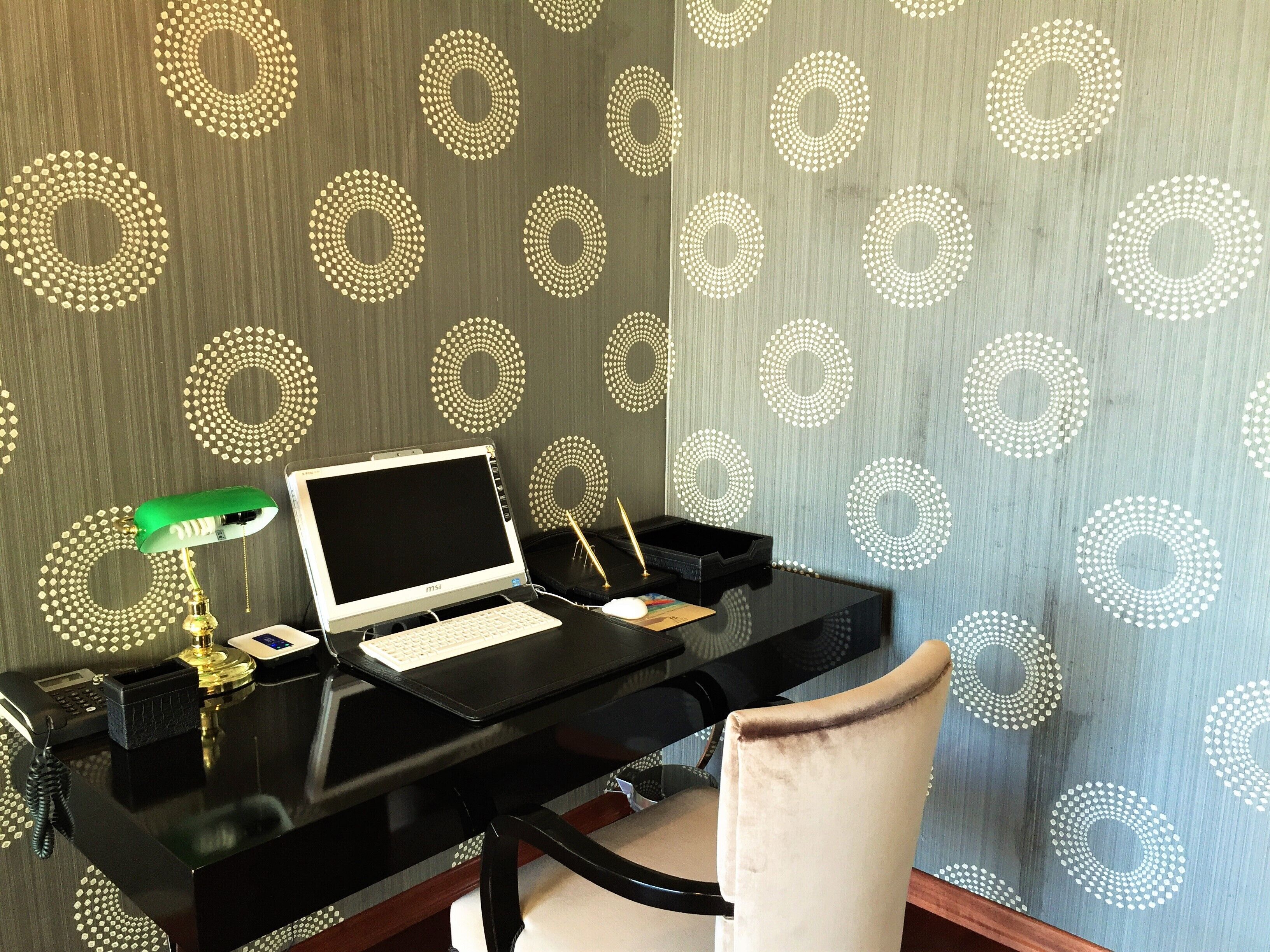 A workspace with a laptop, desk lamp, and telephone.