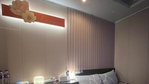 Una habitació d'hotel amb llit, escriptori, cadira i un gran mirall.