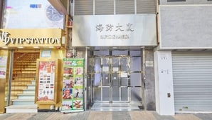 Entrada d'hotel amb una porta de vidre, una màquina expenedora i un cartell que diu VIP Station.