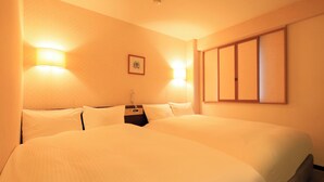 A hotel room with two beds, a bedside table, a phone, and a wall-mounted picture. - Centurion Hotel Hamamatsu (Hamamatsu)