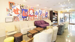 A lobby with seating arrangements, a reception desk, and a wall decorated with colorful artwork. - Centurion Hotel Hamamatsu (Hamamatsu)
