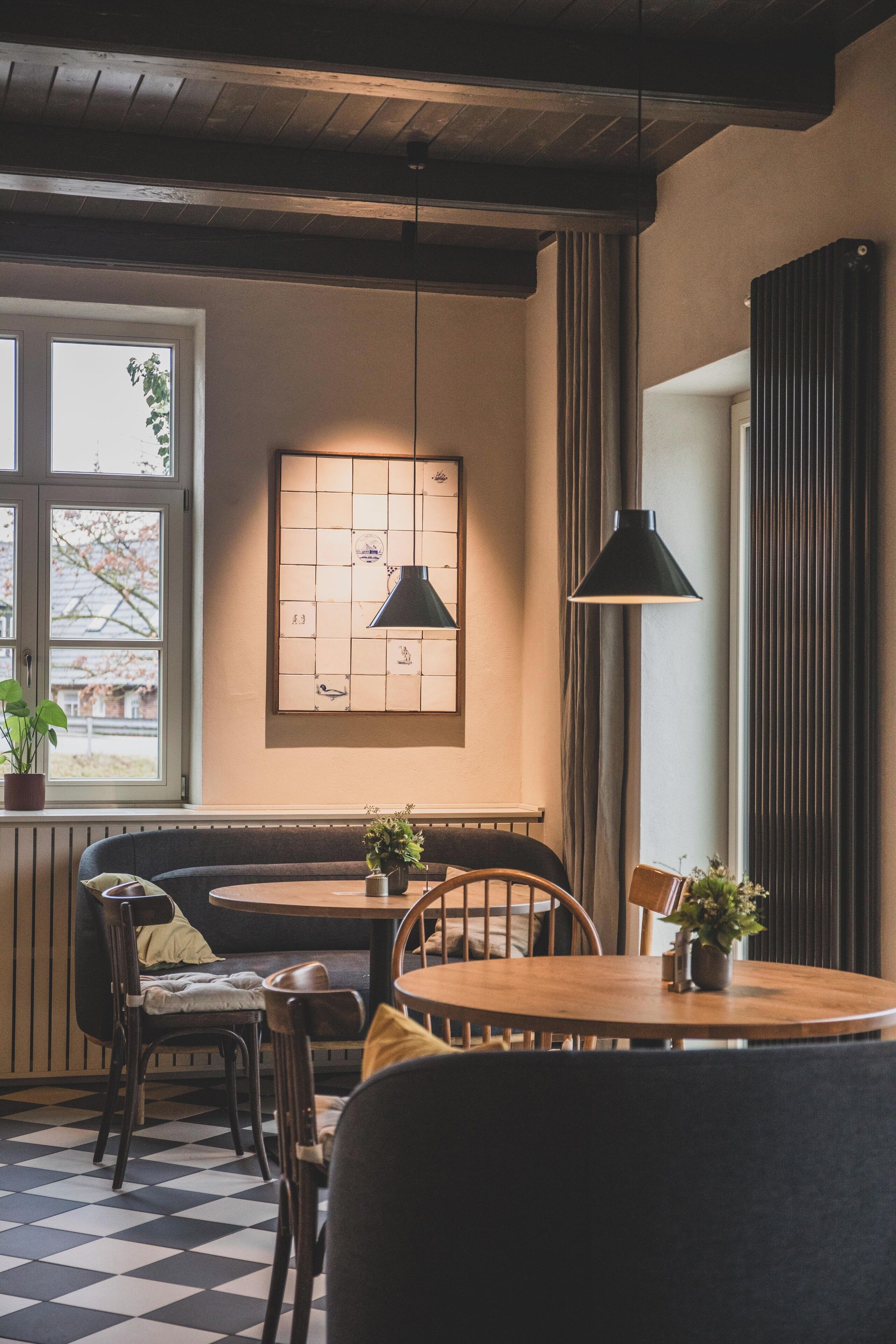 Un rincón comedor acogedor con una mesa y sillas de madera, además de un banco y un cuadro con diseño de cuadrícula.
