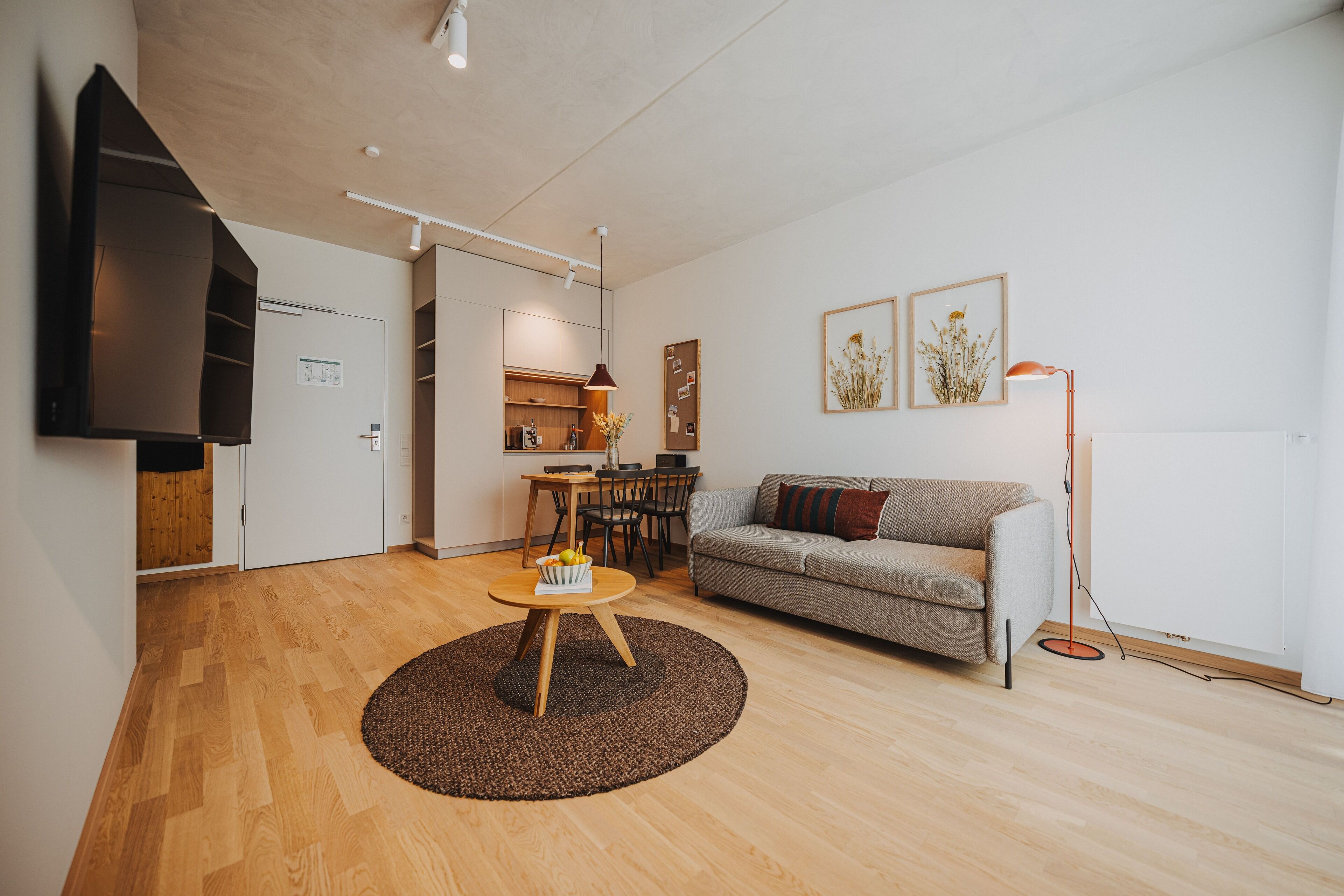 Una sala de estar moderna con sofá, mesa de centro y comedor con sillas y una mesa.