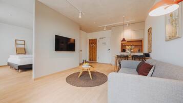 Una sala de estar moderna con un sofá, una mesa de centro y un televisor montado en la pared.