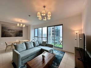 Sala de estar moderna com sofá modular, mesa de centro de madeira e uma janela grande com vista para a cidade.