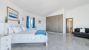 A modern bedroom with a large bed, a bedside table, a wardrobe, and a sofa. - Villa Paraiso Beautiful villa in an enviable position (Carvoeiro)
