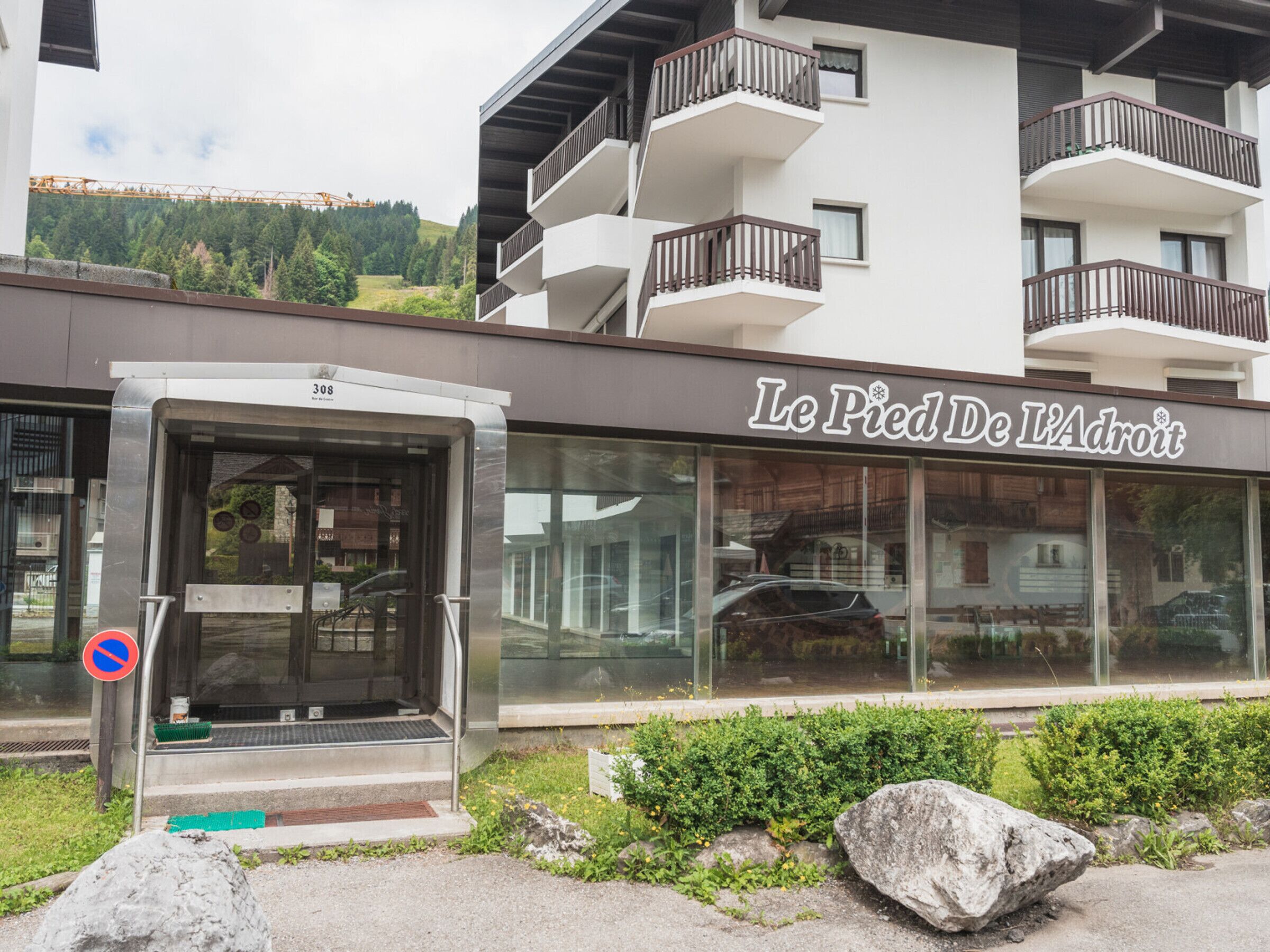 A modern building with a glass storefront and a sign reading "Le Pied De L'Adroit".