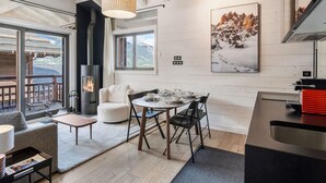 A modern interior with a fireplace, dining area, and a large window offering a mountain view.