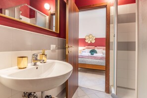 Une salle de bain moderne avec un grand lavabo blanc, des robinetteries dorées et un miroir.