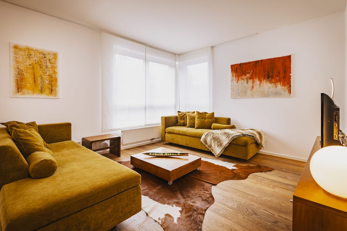 A modern living room with a sofa, a coffee table, and a television.