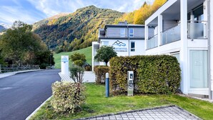 A modern hotel with a mountain view, a paved driveway, and a sign indicating a parking area. - Der Gletscherblick by Alpin Rentals - incl Summercard  (Kaprun)