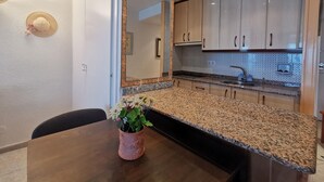 Una cocina moderna con encimeras de granito, electrodomésticos de acero inoxidable y armarios de madera clara.
