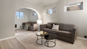 A modern living room with a grey sofa, two armchairs, a coffee table, and a fireplace. - The View (Tromsø)