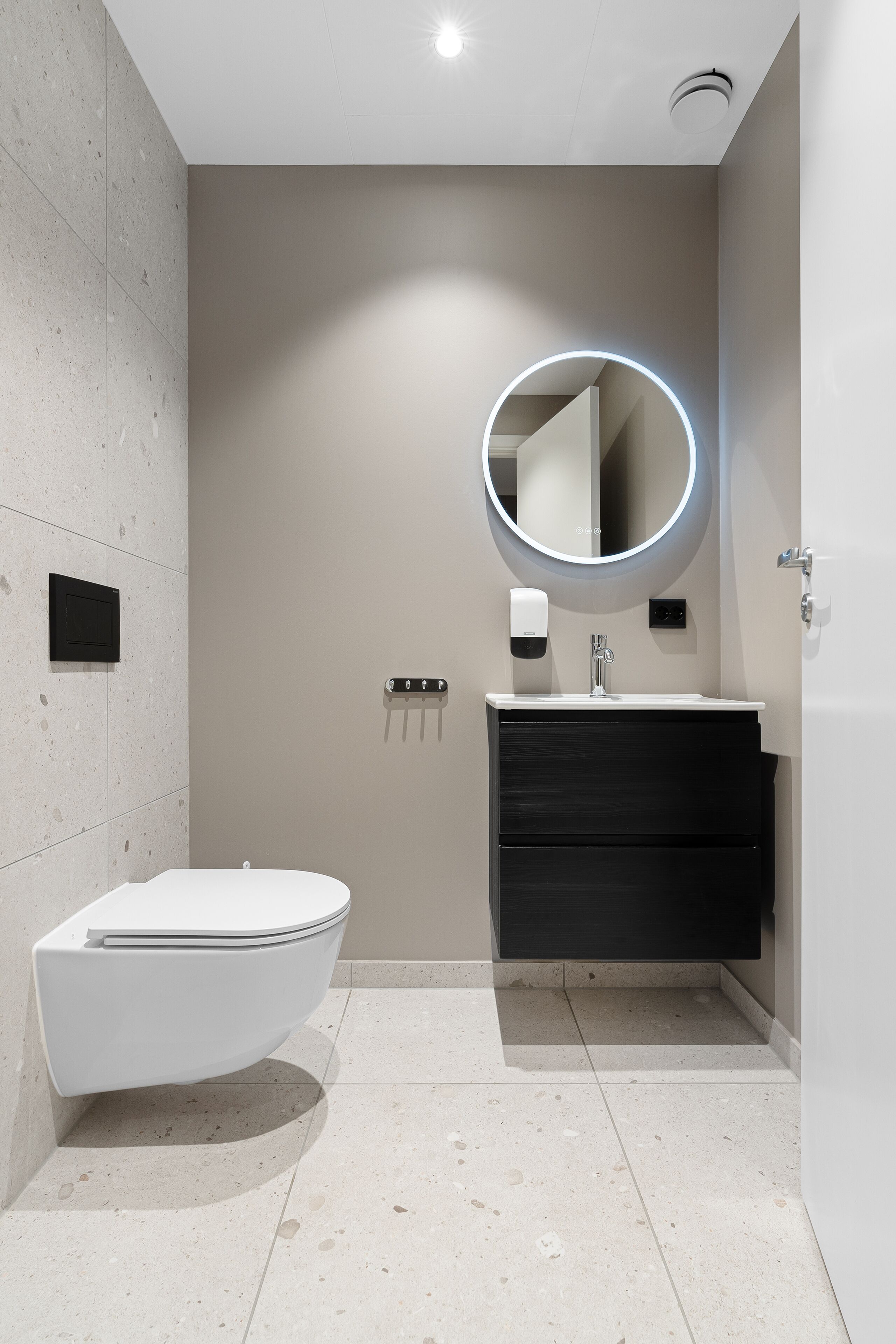 Une salle de bain moderne avec des toilettes, un lavabo et un miroir.