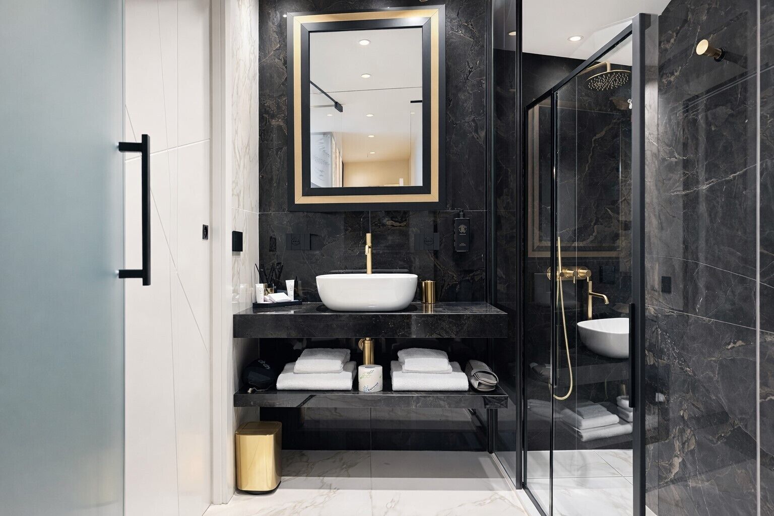Une salle de bain moderne avec un grand miroir, deux lavabos, une douche et des toilettes.