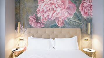 Een slaapkamer met een groot bed, een hoofdeinde, twee nachtkastjes en een bloemenmotief op de muur.