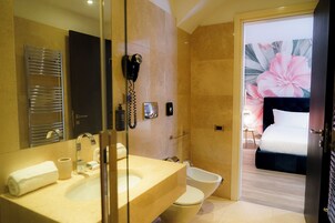 Un bagno moderno con uno specchio grande, un lavandino, un asciugacapelli e un bidet.