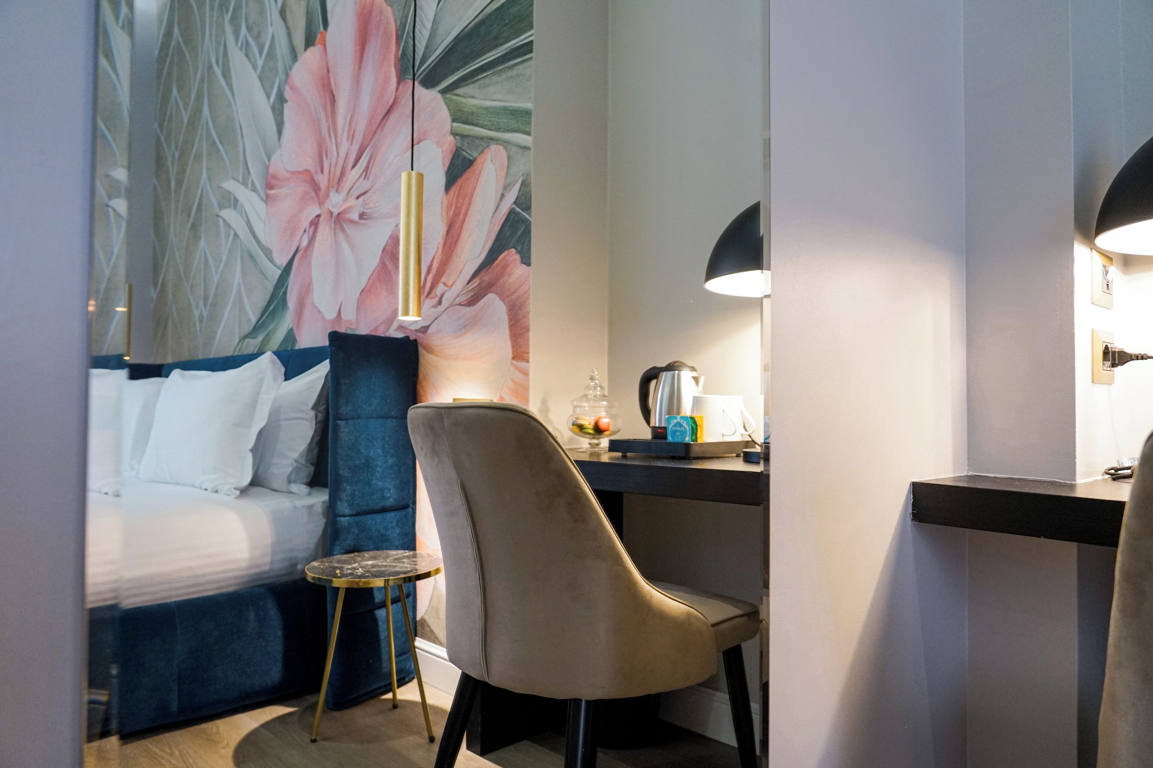 Una habitación de hotel con cama, escritorio, silla y una mesita.