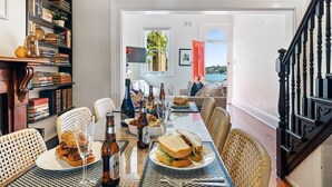 Un comedor con una mesa dispuesta para dos personas, una estantería y vistas al exterior.