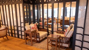 Une pièce de style japonais traditionnel, avec un sol recouvert de tatamis, de petites tables en bois et des sièges rembourrés.