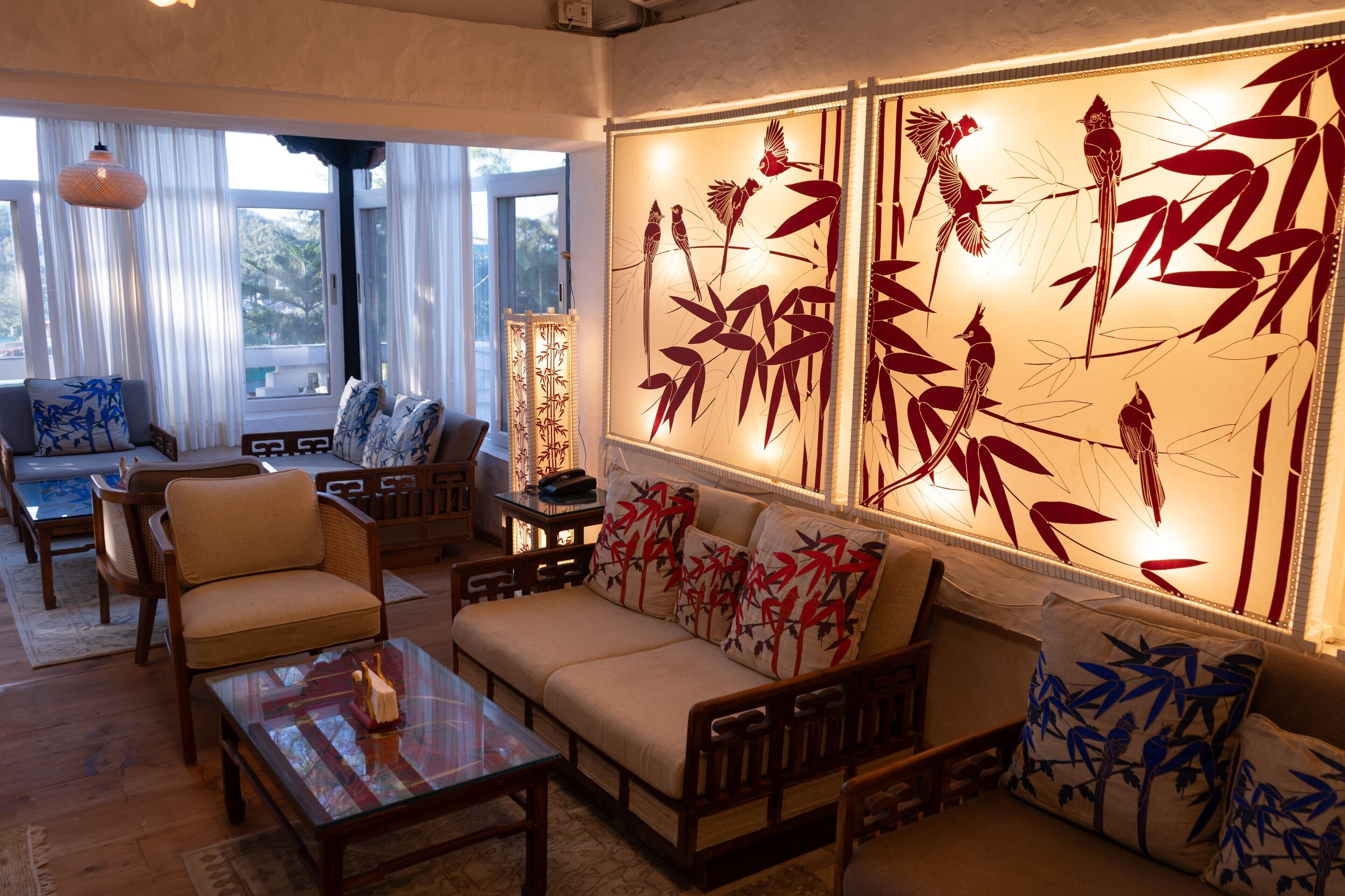 A living room with a sofa, chairs, a coffee table, and a decorative wall with bamboo artwork.
