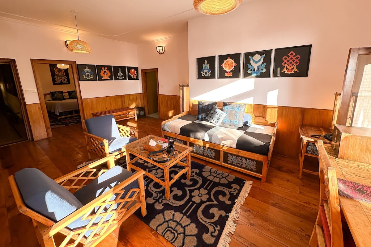 A cozy living room with a sofa, chairs, a coffee table, and artwork on the walls.