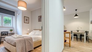 Ein modernes Schlafzimmer mit einem Bett, einem Nachttisch und einem Fenster mit Blick.