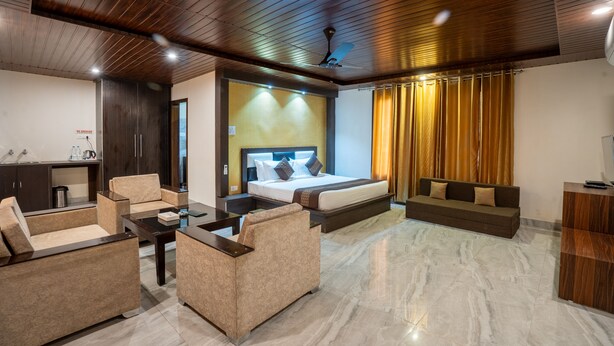 Una habitación de hotel moderna con una cama grande, un sofá, una mesa de centro y un escritorio.