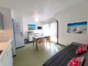 A compact living space with a kitchenette, dining area, and a bed. - Cozy studio for 4 with balcony, parking, and gym in St Lary Soulan (Saint-Lary-Soulan)