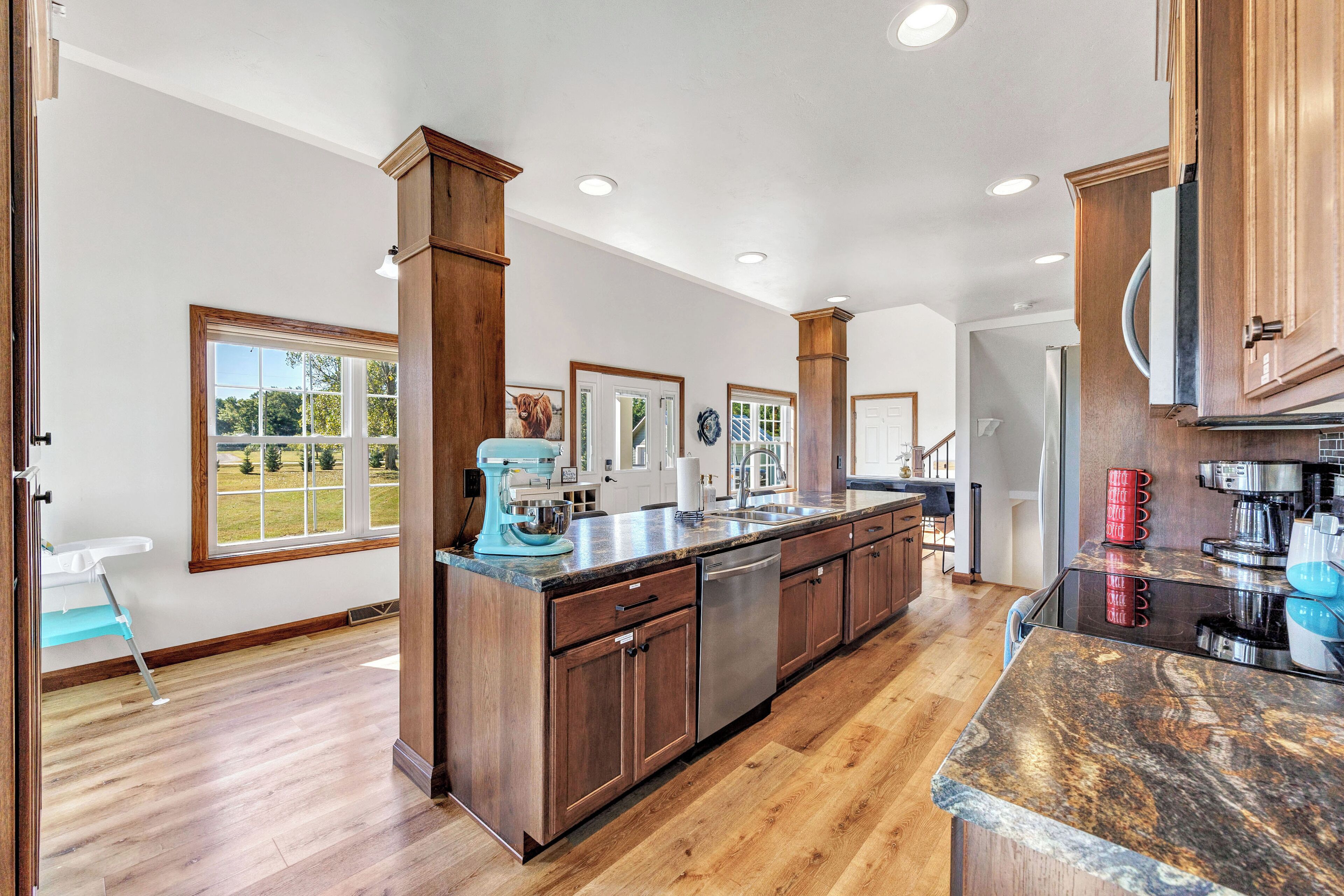 A spacious kitchen with wooden cabinets, a granite countertop, and a dishwasher.