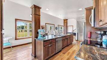A spacious kitchen with wooden cabinets, a granite countertop, and a dishwasher.